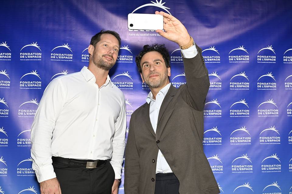 Deux convives prenant un autoportrait devant le mur aux logos