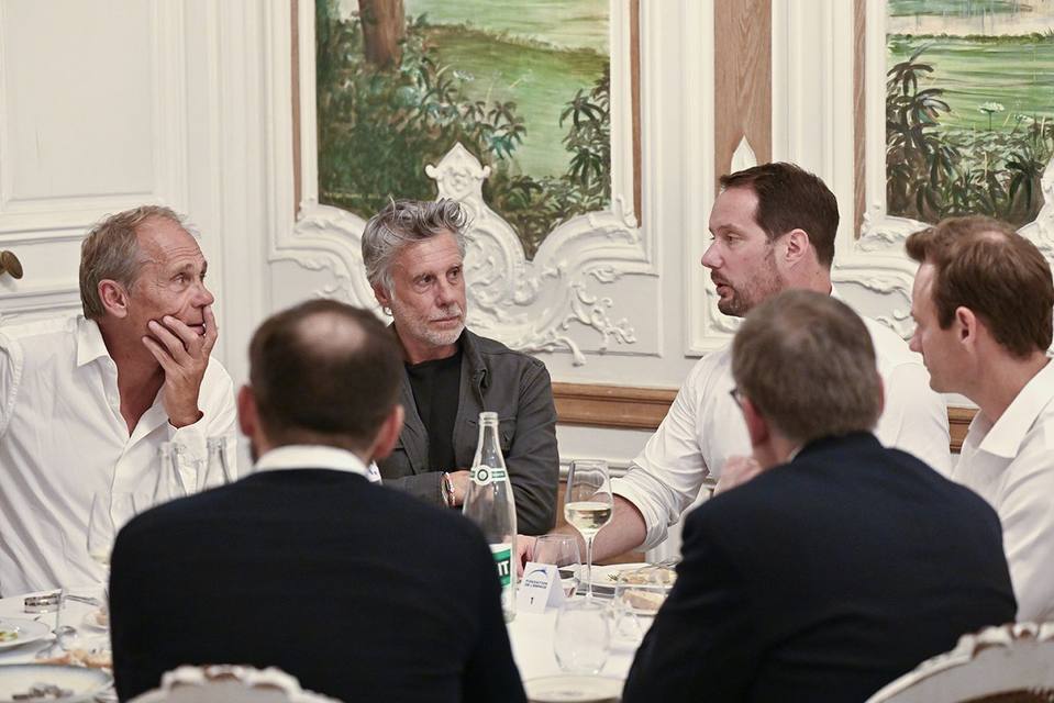Groupe de convives écoutant un échange autour d'une table