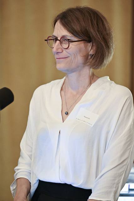 Portrait de Pascale Alix debout près d'un microphone