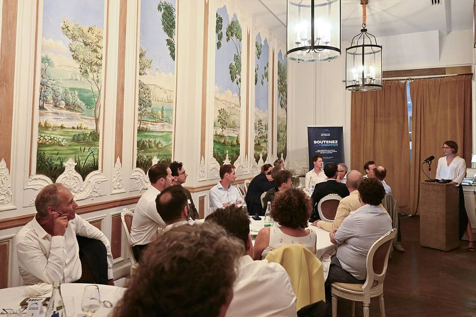 Salon de l'Hôtel Alfred Sommier pendant une prise de parole, convives réunis autour des tables