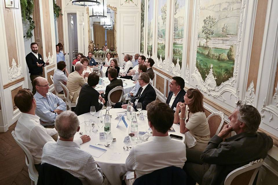 Vue plongeante sur les tables dressées et les convives pendant l'échange