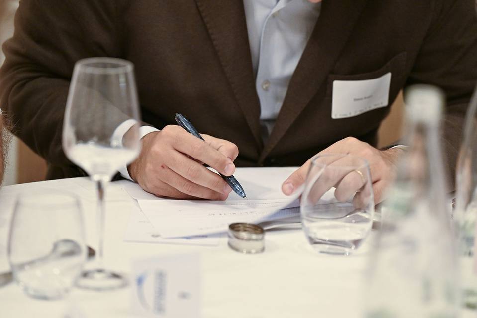Convive complétant un document de soutien à la Fondation pendant le dîner