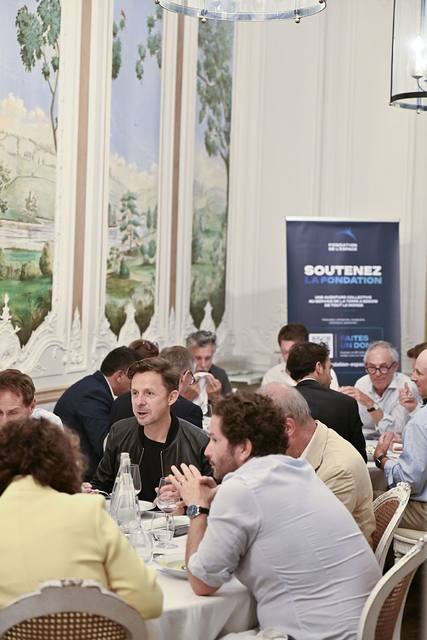 Vue verticale du dîner devant le kakémono Soutenez la Fondation