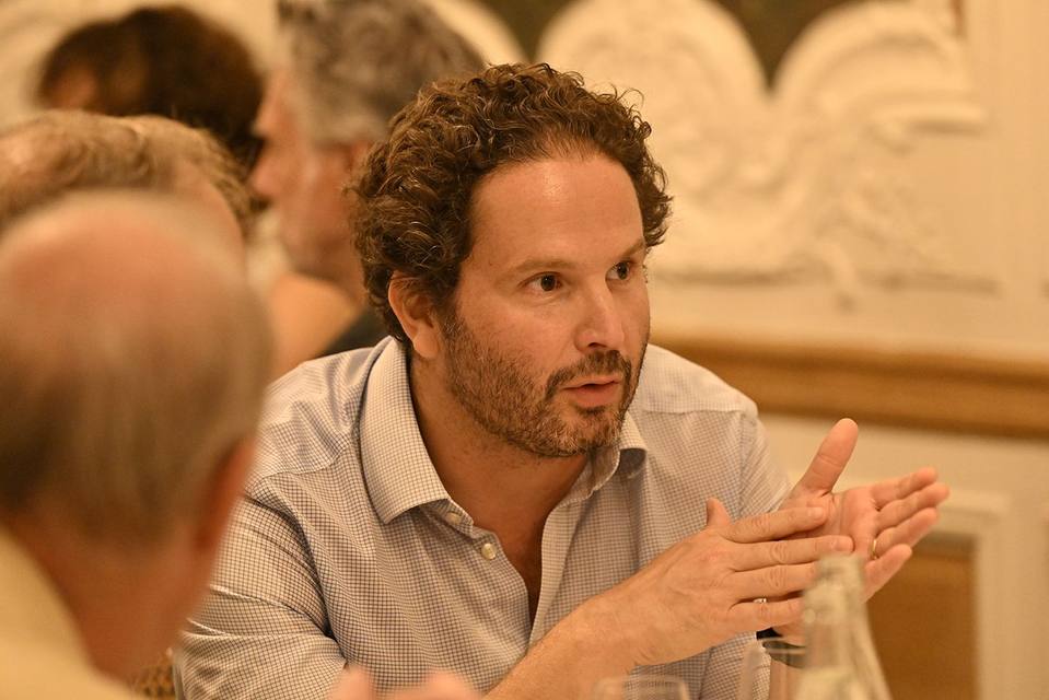 Convive aux cheveux bouclés s'exprimant pendant le dîner
