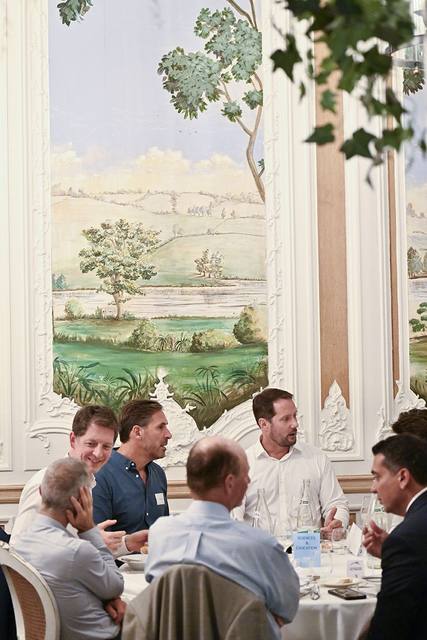 Vue verticale d'une table de convives devant une fresque murale