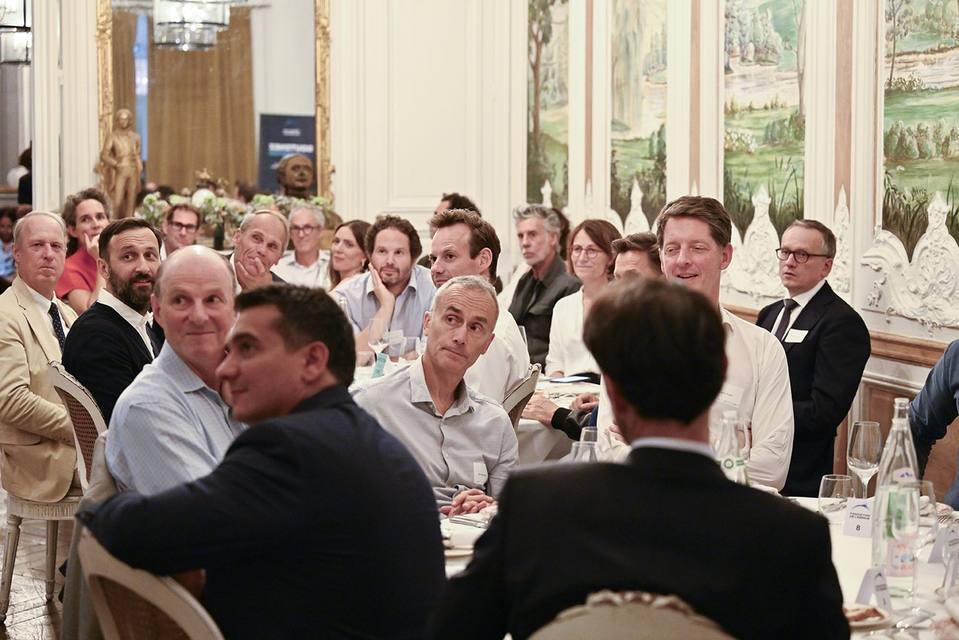 Convives écoutant une prise de parole pendant le dîner