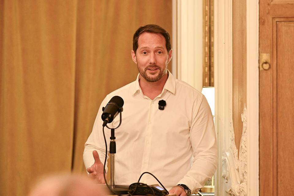 Intervenant au pupitre s'adressant aux convives