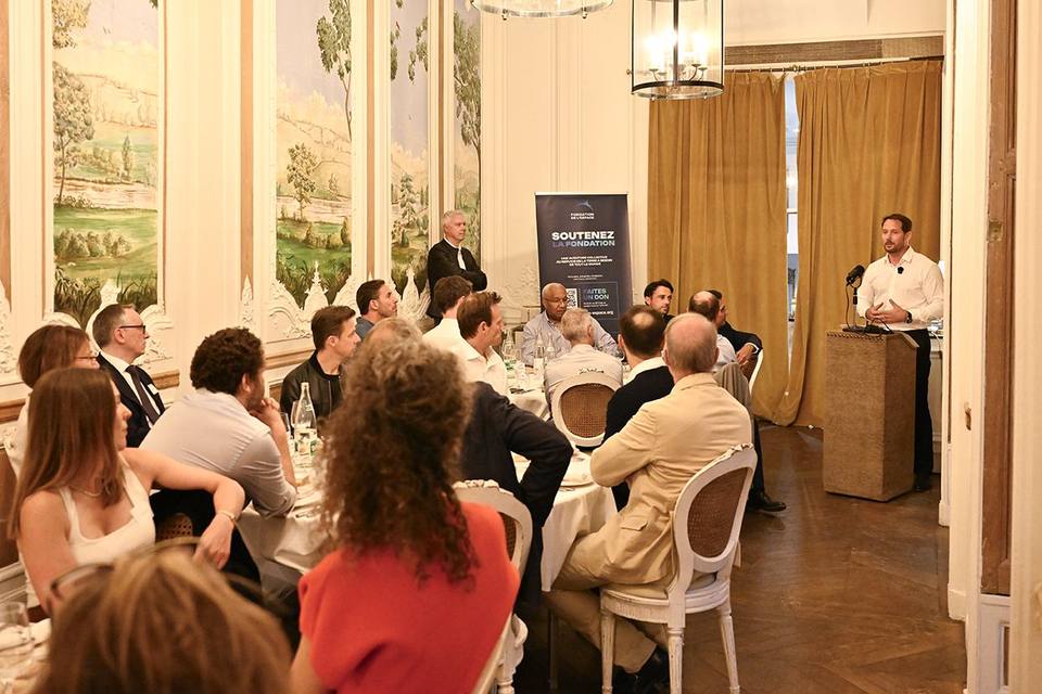Convives attentifs face à l'intervenant et au kakémono de la Fondation